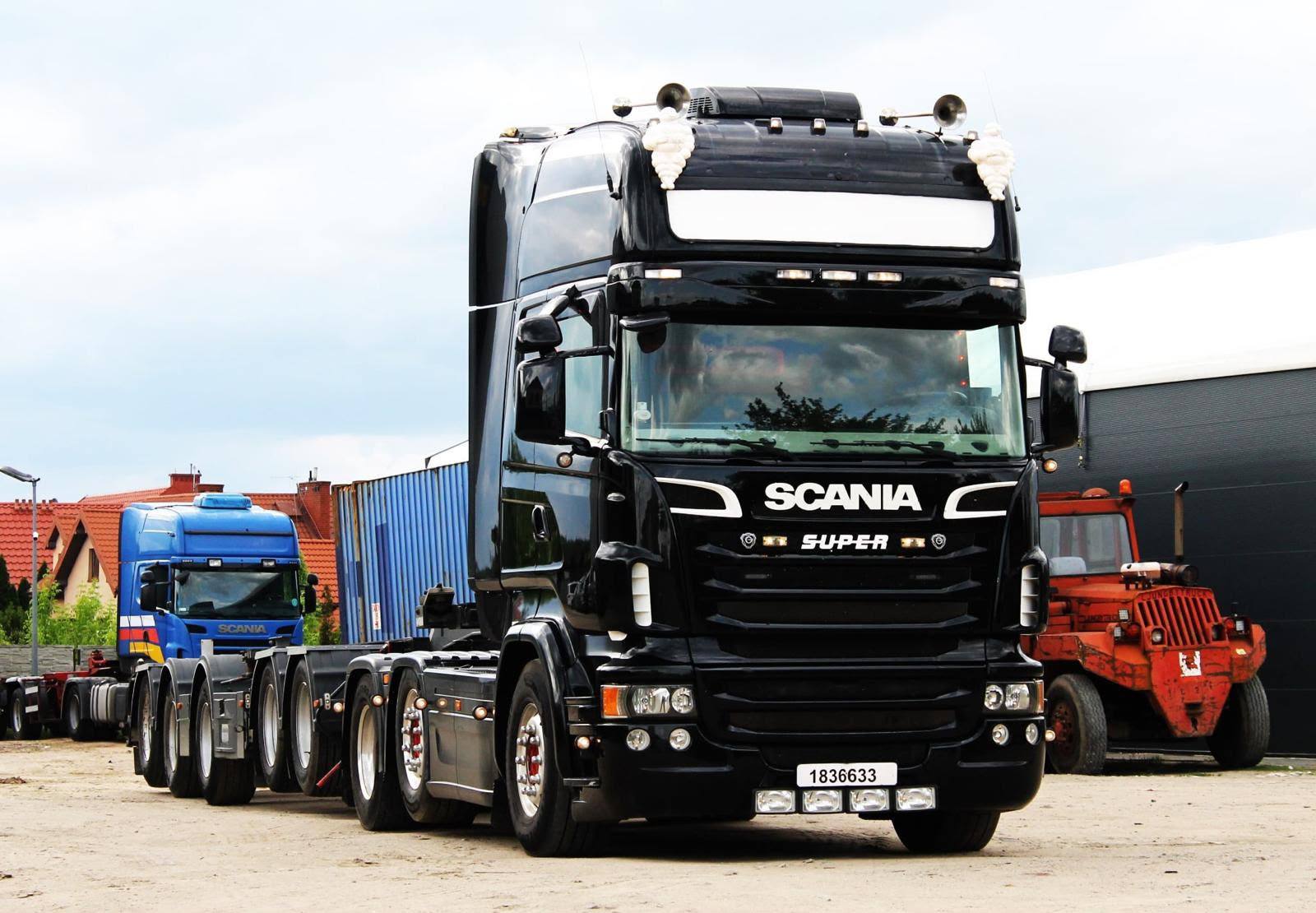 Czarny ciągnik Scania OLETRANS z naczepą podkontenerową na placu w Mławie